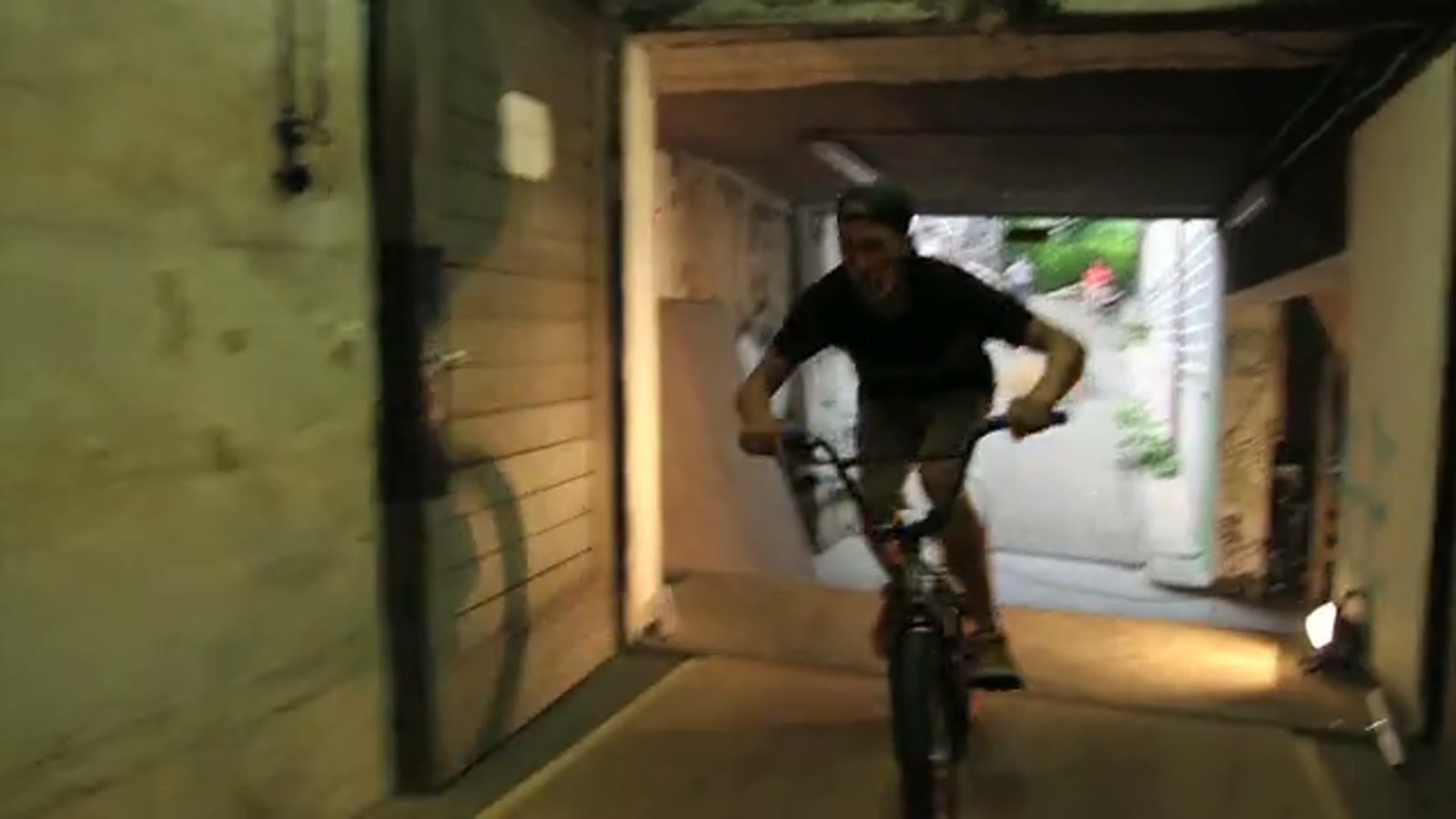 BMX-Fahrer vor einer selbst gebauten Rampe im Hof