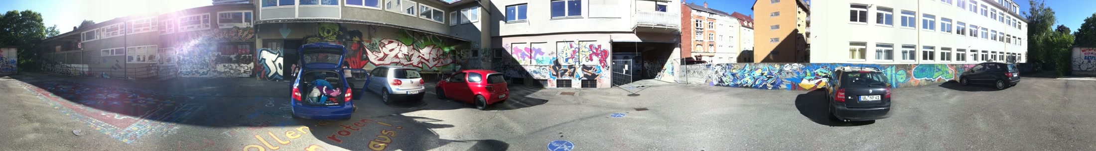 Breites Panorama des Hofs mit Fassade und Veranstaltungsspuren